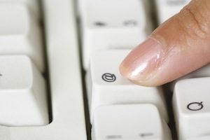 Finger pushing a key on a keyboard